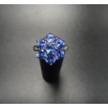 TANZANITE CLUSTER DRESS RING the seven stone tanzanite cluster flanked by a small diamond to each