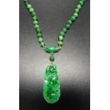 JADE NECKLACE the jade bead necklace with pierced and carved pendant section, with nine carat gold