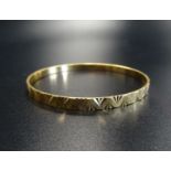 TWENTY-TWO CARAT GOLD BANGLE with engraved geometric decoration, approximately 19.8 grams