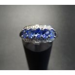 TANZANITE AND DIAMOND DRESS RING the five oval cut tanzanites with small diamonds above and below,