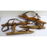 PAIR OF VINTAGE STRAP ON ICE SKATES with leather bindings to a shaped wooden body with metal