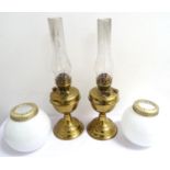 PAIR OF DUPLEX OIL LAMPS with shaped brass bodies, clear glass stacks and opaque bulbous shades,
