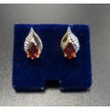 PAIR OF GARNET AND DIAMOND STUD EARRINGS the pear cut garnet on each in teardrop shaped setting with