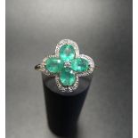 EMERALD AND DIAMOND CLUSTER RING the four oval cut emeralds in diamond set quatrefoil surround, on