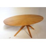 LIGHT OAK OVAL DINING TABLE with a segmented design top standing on four cross shaped supports,