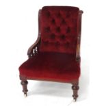 VICTORIAN MAHOGANY FRAMED NURSING CHAIR with shaped armrests, raised on front turned legs, with