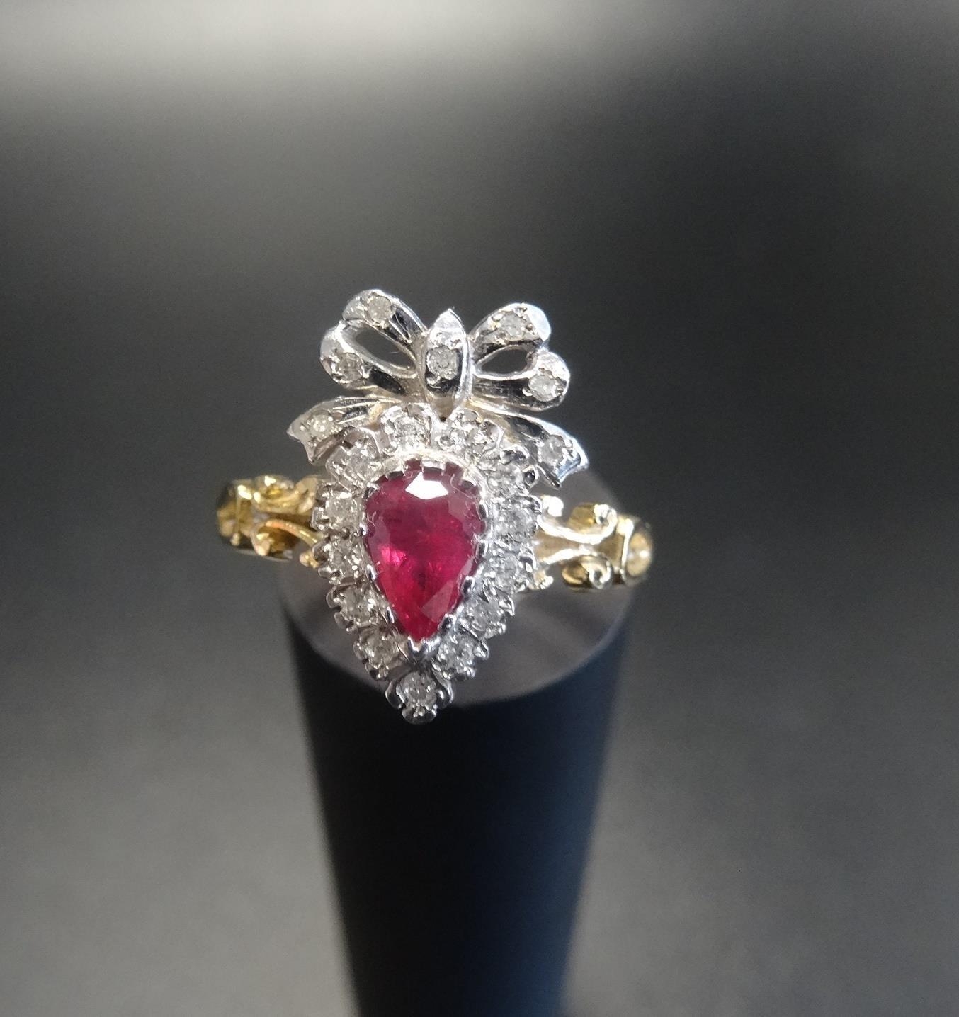 UNUSUAL RUBY AND DIAMOND CLUSTER RING the pear cut ruby in diamond surround and surmounted by a