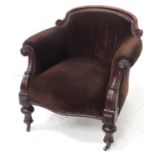 VICTORIAN MAHOGANY FRAMED TUB CHAIR with shaped back, carved facing arms and raised on turned