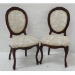 PAIR OF WALNUT FRAME SIDE CHAIRS with oval carved padded backs above stuffover seats, standing on