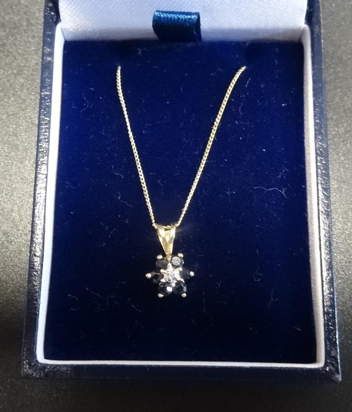 SAPPHIRE AND DIAMOND CLUSTER PENDANT in nine carat gold and on nine carat gold chain