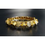 UNUSUAL TWENTY-TWO CARAT GOLD BANGLE with raised decoration, approximately 18.5 grams