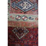 MIDDLE EASTERN WOOLLEN RUG with stylised geometric motifs, fringed to two ends on end trimmed, 127cm