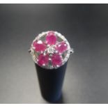 RUBY AND DIAMOND CLUSTER RING the five oval cut rubies and central diamond forming a flower head,