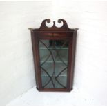 GEORGE III MAHOGANY CORNER CABINET with a scroll shaped pediment above a beaded glazed door, with