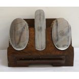 THREE SILVER BACKED BRUSH SET comprising two oval and one oblong brush, all with 'GFR' monogram to