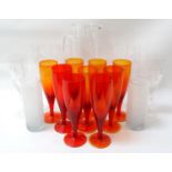 SELECTION OF GLASSWARE including nine orange glass champagne flutes, four champagne flutes with