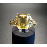 YELLOW BERYL AND PERIDOT RING the emerald cut beryl flanked by small round cut peridots, on nine