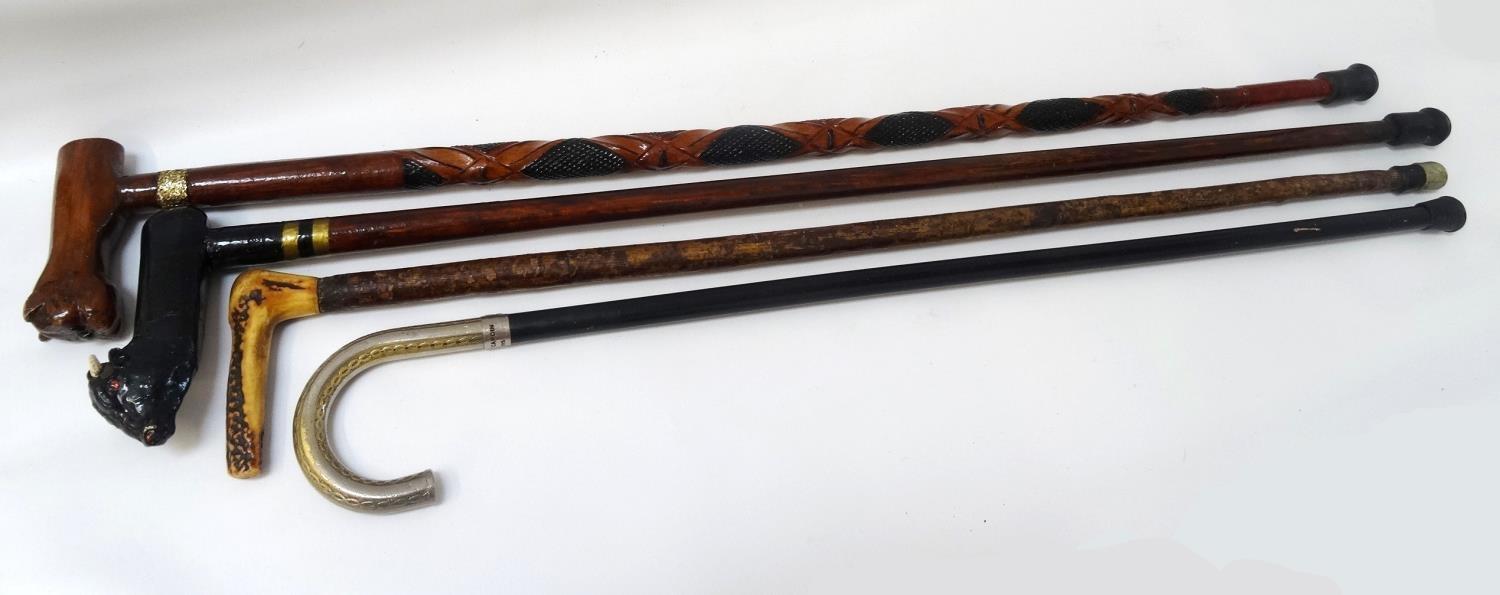 SELECTION OF FOUR WALKING STICKS one with an ebonised cane and white metal handle marked Pierre