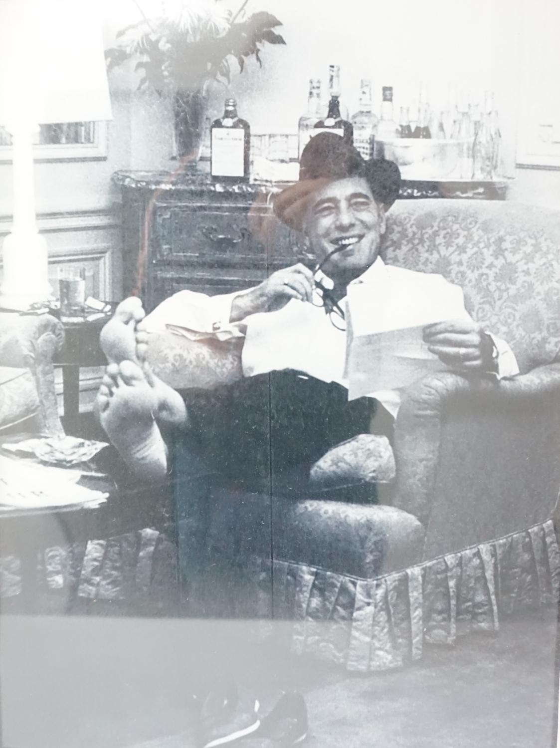 HUMPHREY BOGART (1899-1957) PHOTOGRAPHIC REPRODUCTION depicting him reclining with his feet up,