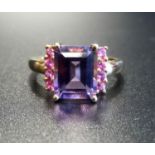 AMETHYST AND PINK GEM SET DRESS RING the central emerald cut amethyst approximately 2.5cts flanked