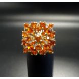 CITRINE CLUSTER RING the varying sizes of round cut citrines in pierced square cut setting, on