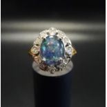 OPAL TRIPLET AND DIAMOND CLUSTER RING the central oval opal triplet in twelve diamond surround, on