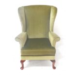 THREE PARKER KNOLL WING BACK ARMCHAIRS all covered in a pea green coloured material, standing on