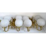 SET OF FOUR GILT BRASS WALL LIGHTS each with a pair of scroll arms and opaque circular glass