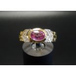 PINK TOPAZ AND DIAMOND DRESS RING the central bezel set oval cut topaz flanked by three diamonds