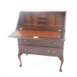 WALNUT BUREAU with a figured walnut fall front opening to reveal a fitted interior with three