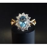 BLUE TOPAZ AND DIAMOND CLUSTER RING the central oval cut topaz in twelve diamond surround, on nine