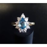 BLUE TOPAZ AND DIAMOND CLUSTER RING the central pear cut blue topaz in nine diamond surround, on