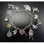 SILVER CHARM BRACELET with silver heart padlock clasp and a large selection of mostly silver charms,