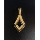 DIAMOND SET NINE CARAT GOLD PENDANT of shaped design with pierced centre