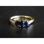 SAPPHIRE AND DIAMOND RING the three graduated oval cut sapphires flanked by small diamonds to the
