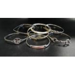 EIGHT SILVER BANGLES of various designs, including one with gilt detail and another with mother of