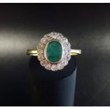 EMERALD AND DIAMOND CLUSTER RING the bezel set oval cut emerald approximately 0.75cts in sizteen