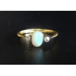 OPAL AND DIAMOND THREE STONE RING the central oval opal flanked by diamonds, on eighteen carat
