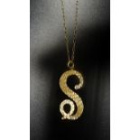 NINE CARAT GOLD 'S' SHAPED PENDANT with textured detail, on nine carat gold chain, total weight