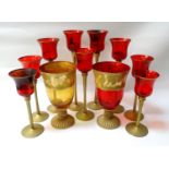 SELECTION OF DECORATIVE GLASS TEA LIGHT HOLDERS nine of graduated size with ruby red bowls on gold