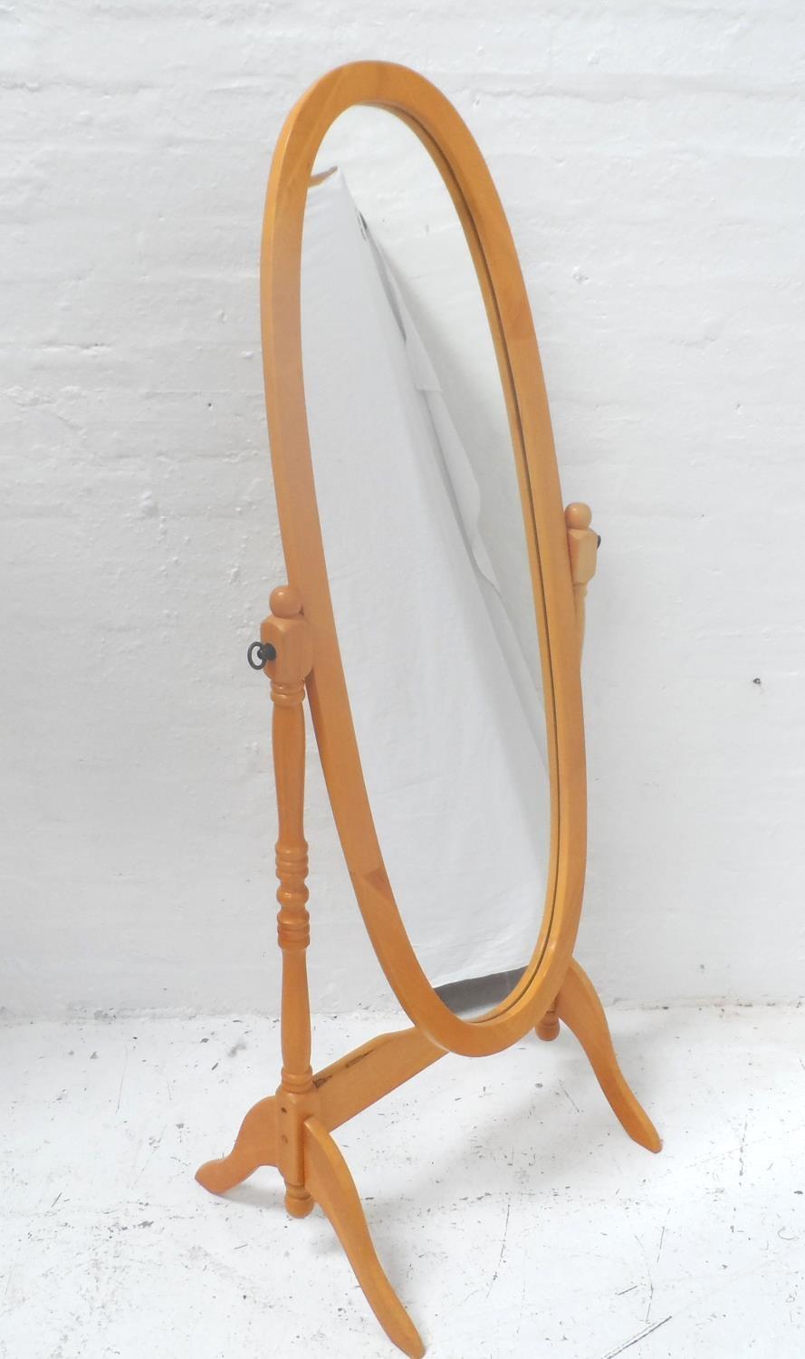 OVAL BEECH CHEVAL MIRROR supported by turned arms and standing on splayed supports, 155cm high