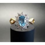 BLUE TOPAZ AND DIAMOND CLUSTER RING the central oval cut topaz in twelve diamond surround, on nine