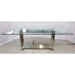 MONACO DINING TABLE by Giorgio Cattelan with an oblong glass top mounted on a polished steel