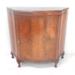 MAHOGANY CREDENZA of shaped outline with a central door opening to reveal a shelved interior,
