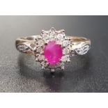 RUBY AND DIAMOND CLUSTER RING the central oval cut ruby within diamond surround, with further