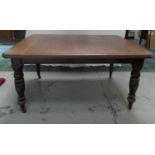 LATE VICTORIAN OAK DINING TABLE with canted corners to the wind out top, standing on turned and