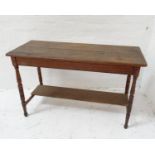 EDWARDIAN PINE SIDE TABLE with a moulded plank top, standing on turned tapering supports united by