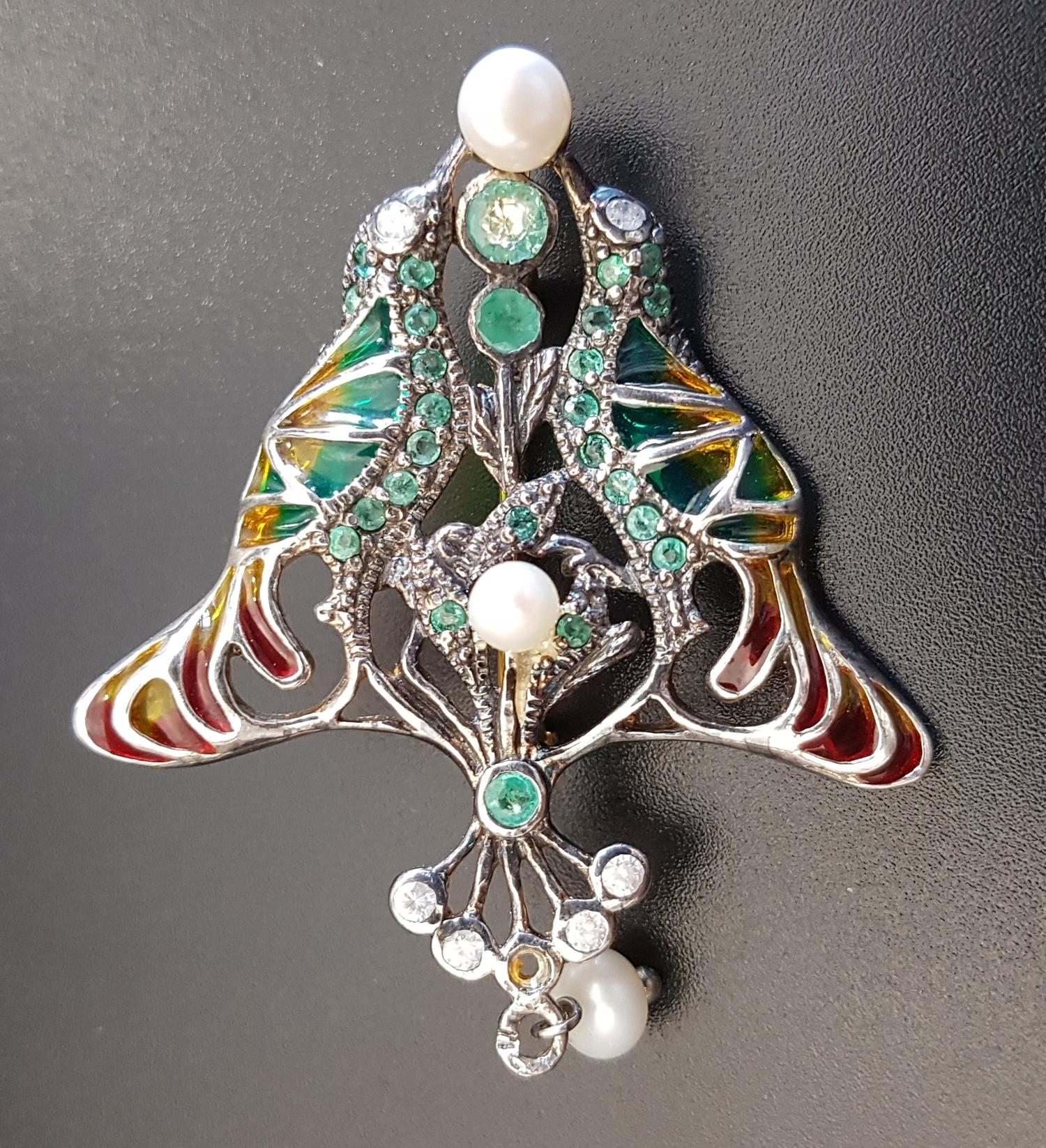 UNUSUAL DIAMOND, EMERALD AND PEARL SET BIRD BROOCH with colourful filled panels to represent the