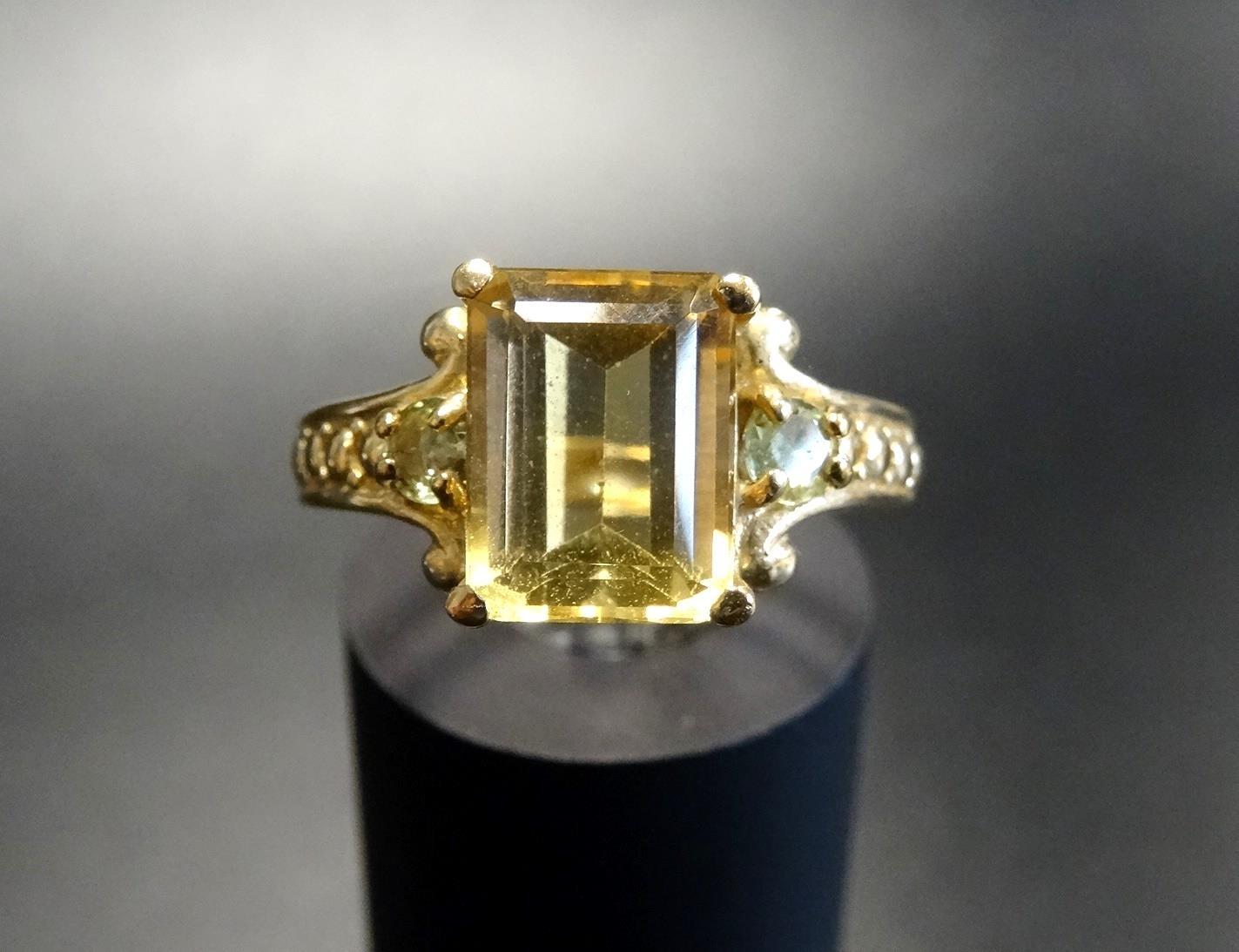 YELLOW BERYL AND PERIDOT DRESS RING the central emerald cut yellow beryl flanked by a round cut