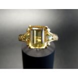 YELLOW BERYL AND PERIDOT DRESS RING the central emerald cut yellow beryl flanked by a round cut
